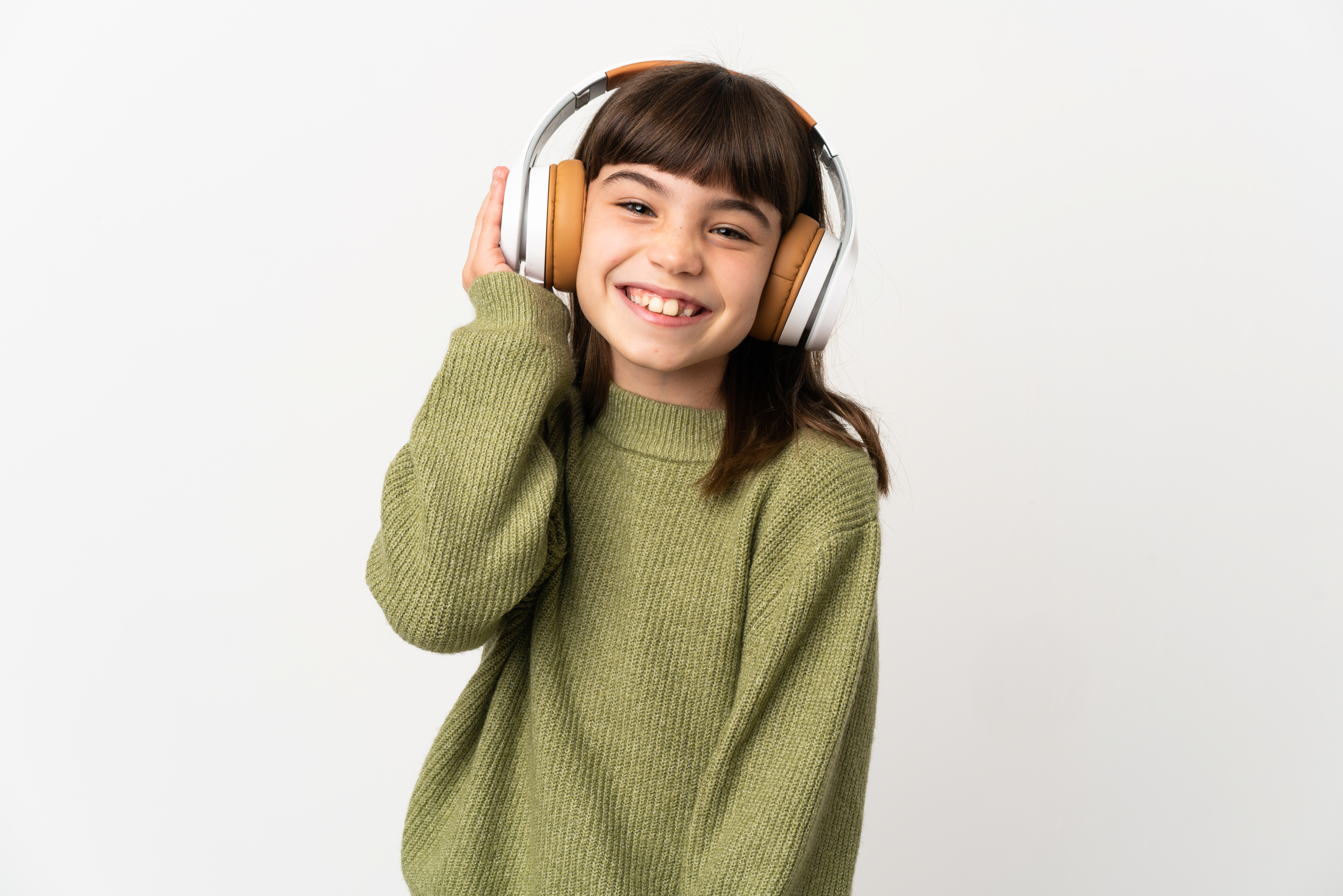 Little girl listening music with a mobile isolated on white background listening music